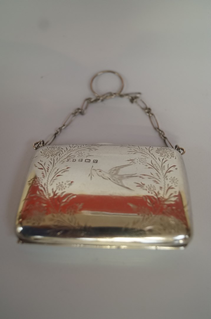 A silver purse, maker F. D., Birmingham 1920, engraved with flora and a bird, on a chain, 8cm long