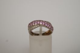 A diamond and pink sapphire dress ring, of pave cross over design, finger size J