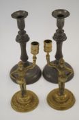 A pair of brass candlesticks in the form of knights , along with a pewter pair