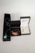A three stone pendant on chain, a turquoise pendant on chain and a locket and chain, all boxed