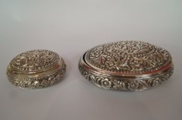 An oval embossed box, 8.6cm long, with a smaller example, possibly Middle Eastern