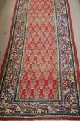 A Tabriz runner rug, light red with repeated design in centre, 437 x 86cm