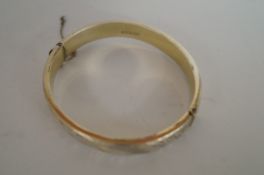 A silver hinged bangle, half engraved decoration; approximately 18 grams