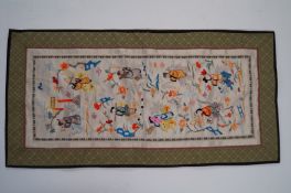 An oriental silk wall hanging decorated with typical scenes