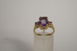 A three stone amethyst 9ct gold dress ring, finger size N