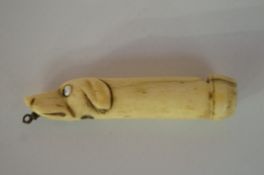 A dog shaped whistle with Stanhope lens showing scenes of Whitby