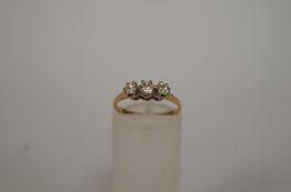 A three stone diamond 18ct gold ring, the graduated brilliant cuts totalling approximately 0.
