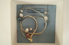 A three drop cultured pearl pendant on a chain with a pair of matching earrings