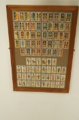 A set of framed cap badges and uniform cigarette cards