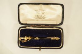 A brooch in the form of a naval sword, stamped 14ct, in a Gieves box