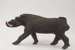 A carved wooden figure of a Warthog