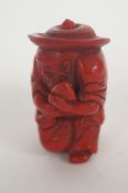A red figure of an oriental man holding a fish