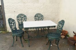 20th century marble topped and cast iron garden table and four cast iron decorative chairs