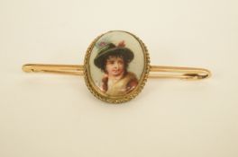 A bar brooch set with a German transfer printed image of a boy, the bar stamped '15ct'