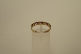 A diamond and ruby 9ct gold eternity ring, the five rubies with single cuts between, finger size