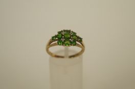 An eleven stone Tsavorite 9ct gold ring with four single cut diamond points, finger size O 1/2, 2.5