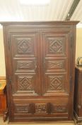 A 17th century and later Spanish oak armoire, carved in relief with six panels to the doors, above