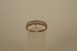 A seven stone cubic zirconia 9ct gold ring, finger size L1/2, 1.1g gross