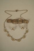 A set of silver filigree jewellery comprising a necklace, a bracelet and a pair of ear studs, cased