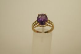 An amethyst and peridot 9ct gold dress ring, the oval cut amethyst with a trio of peridots to each