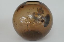 A goldfish bowl with smoky glass with different kinds of fish and a large vase decorated with