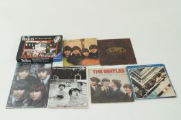 Four Beatles records, a Beatles jigsaw, a telegraph article on the Beatles and a calendar