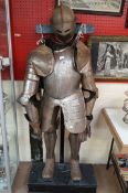 An early 20th century suit of armour on wooden stand