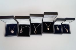 Six boxed silver pendants and chains