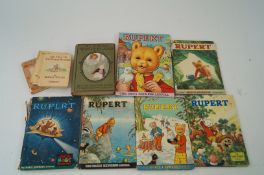 Six various Rupert annuals, along with five Beatrix Potter books and Alice in Wonderland