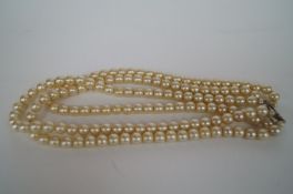 A three strand pearl necklace with silver clasp