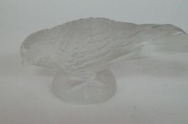 A decorative glass bird bears a Lalique mark