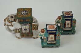 A pair of small ceramic decorative elephants and one other