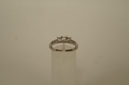 A three stone diamond 18ct white gold ring, the uniform brilliant cuts totalling approximately 0.