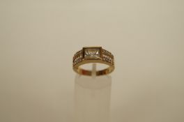 A cubic zirconia 9ct gold dress ring the central scissor cut stone between baguette channel set