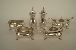A matched six piece silver cruet set with mustard spoons and only one glass liner, 298g (9.6 troy