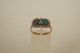 A triple cluster 9ct gold ring, the three blue oval cut stones enclosed by cubic zirconias, finger