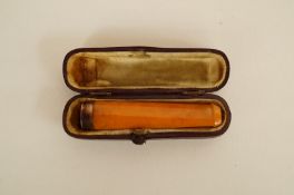 A reconstituted amber and 9ct gold mounted cheroot holder, 6.5cm long, 7.5g gross, cased