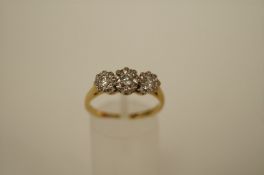 A three stone diamond 18ct gold ring the graduated illusion set brilliant totalling approximately