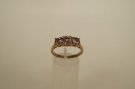 A three stone 9ct gold amethyst dress ring, set with graduated round cuts, finger size S 1/2, 3.5g