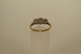 A three stone diamond ring, the illusion set old brilliant cuts totalling approximately 0.2cts