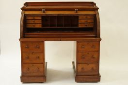 An early 20th century mahogany roll top office desk
