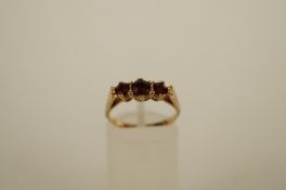 A three stone garnet 9ct gold ring, finger size L, 2.2g gross