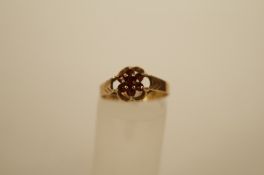 A seven stone 9ct gold garnet cluster ring, 1.7g gross