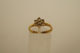 A seven stone diamond 18ct gold cluster ring, the brilliant cuts totalling approximately 0.56cts