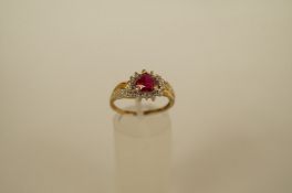A synthetic ruby and diamond cluster 9ct gold ring, the heart shaped stone with three single cut