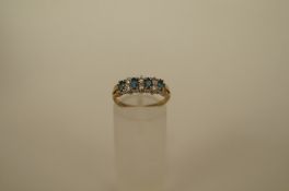 A cubic zirconia dress 9ct gold ring with four oval cut blue stones with pairs of cubic zirconia