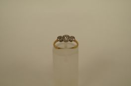 A three stone diamond ring, the illusion set brilliant totalling approximately 0.17cts, finger