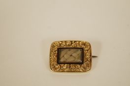 A George IV hair panel mourning brooch the rectangular glazed panel with black enamel trim and
