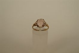 A rose quartz 9ct gold ring the cabochon cut stone to a pierced shouldered mount, finger size L1/