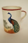 A Wemyss mug decorated with a peacock design, impressed mark. 14cm H